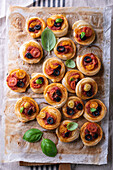 Vegan puff pastry snails with tomatoes, olives and basil