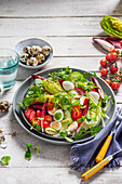 Salat mit Wachteleiern, Brunnenkresse, Erdbeeren, Cherrytomaten, Endiviensalat und Gurke