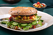 A wholemeal bagel with a vegan patty, lettuce and pepper-and-sweetcorn salsa