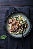 Spelt spaghetti with spinach pesto, spinach, pine nuts and aubergine