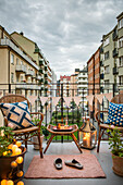 Two chairs and side table on balcony illuminated by lantern and cotton ball fairy lights