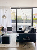 Black sofa and arc lamp in front of terrace doors in living room