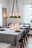 Dining table with festive decorations, hanging Advent wreath