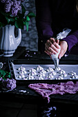 Meringue dots being piped onto a baking tray