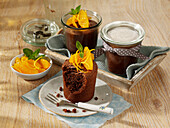 Chocolate cake in glass jars with orange compote