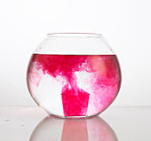 Pink chemical diffusing in water