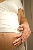 Pregnant woman with hands on baby bump