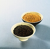 Black and white mustard seeds in ceramic bowls