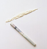 Rolled up note and line of powder