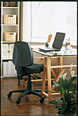 Chair with adjustment levers and desk with lap-top computer