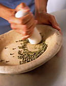 Using pestle to grind seeds