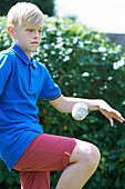 Boy practising keepie uppies with paper ball