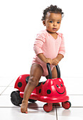 Girl standing over ride on ladybird toy