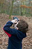 Boy looking up through binoculars