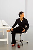 Woman in business suit performing stretching exercise