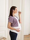 Pregnant woman drinking glass of water
