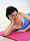 Woman lying down on an exercise mat