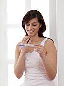 Woman looking at pregnancy test result