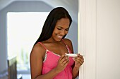 Young woman looking at pregnancy test result