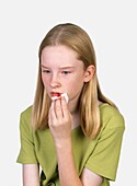 Girl holding tissue on bleeding lips