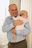 Grandfather holding baby granddaughter in his arms