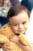 Baby boy hugging teddy bear