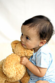Baby boy hugging teddy bear