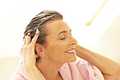 Woman running fingers through hair covered in cream