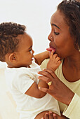 Woman sticking out tongue at baby boy