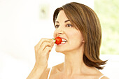 Woman biting strawberry