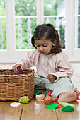 Girl playing with plastic fruit and vegetables