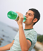 Teenage boys drinking from bottle