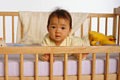 Baby on his stomach in a cot