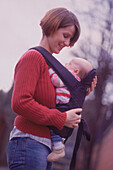 Woman holding baby in a sling on her front