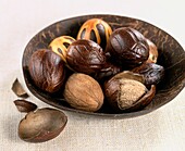 Nutmeg seeds in brown bowl
