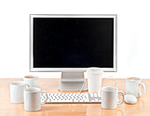 Full and empty cups on desk around computer