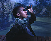Boy looking at the sky through a pair of binoculars