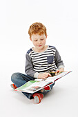 Boy sitting cross-legged reading