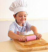 Boy using rolling pin to flatten cookie dough