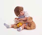 Girl with toy rabbit and teddy bear