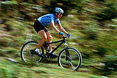 Female cyclist riding mountain bike downhill