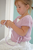 Girl wearing white skirt and pink knitted wrap cardigan