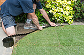 Man edging a new curved lawn edge