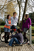 Group of teenagers with bicycle and skateboard in a park