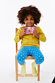 Little girl playing with pink camera