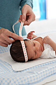 Four week old baby having it's head measured