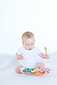 Baby boy playing toy xylophone