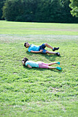 Boy and girl rolling down a hill
