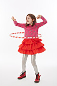 Girl in red skirt playing with hulahoop