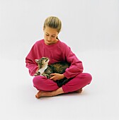 Girl sitting cross-legged with cat on lap